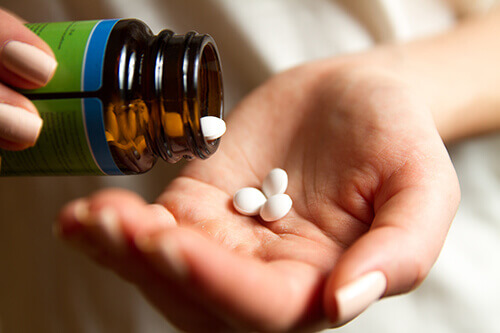 prescription-drug-abuse Woman holding pills in her hand
